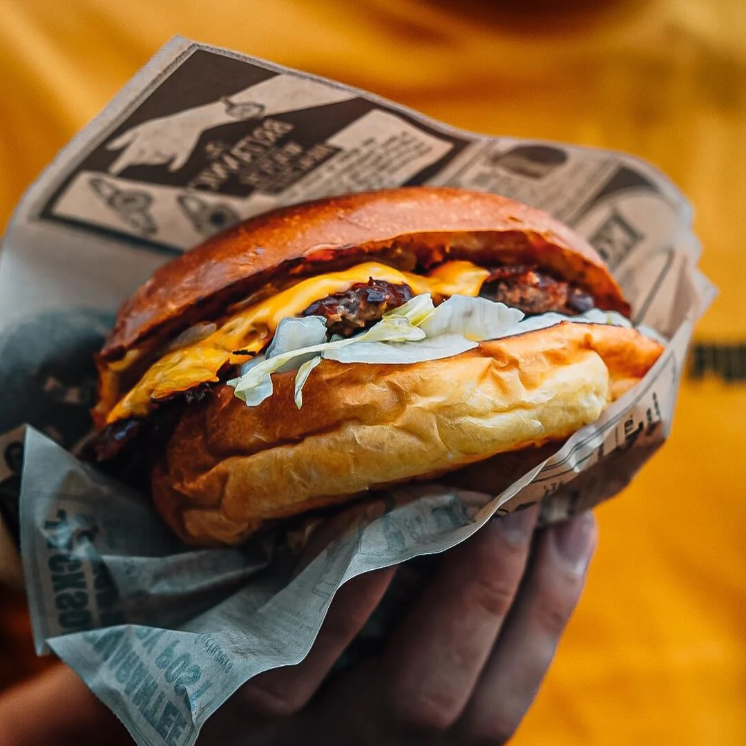 Un smash burger tenu en main